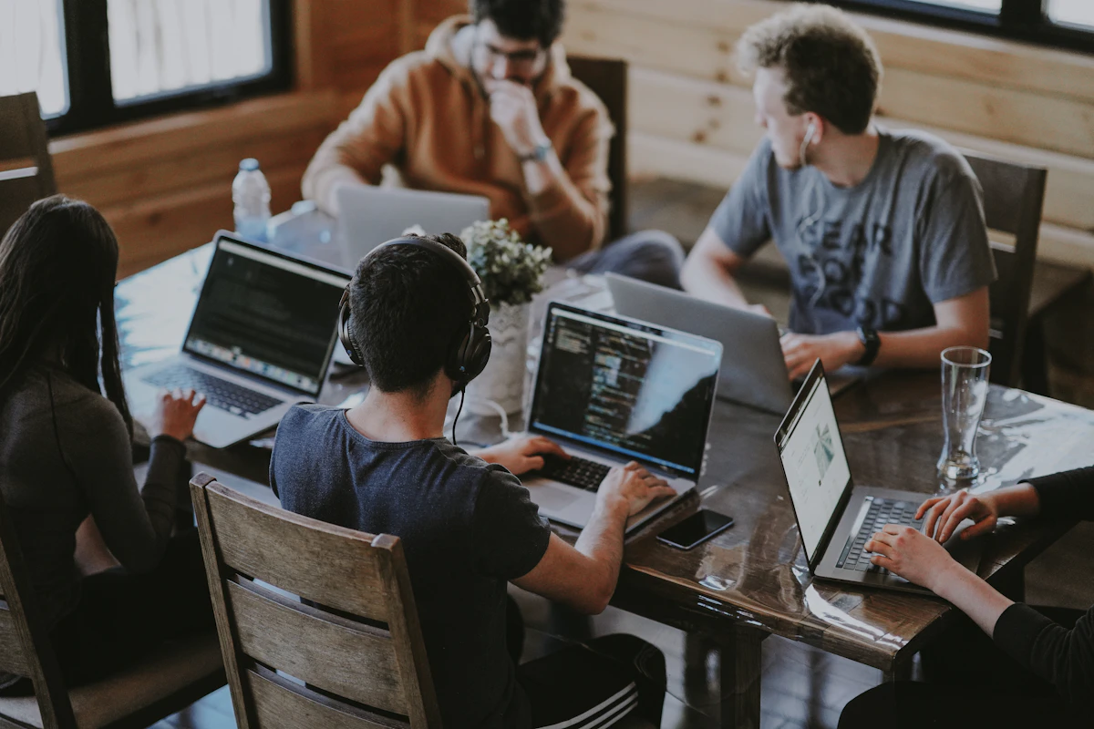 A group of people working together around a laptop